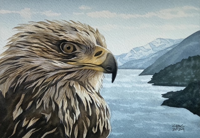 A bald eagle painting with mountains in the background made in Skagway